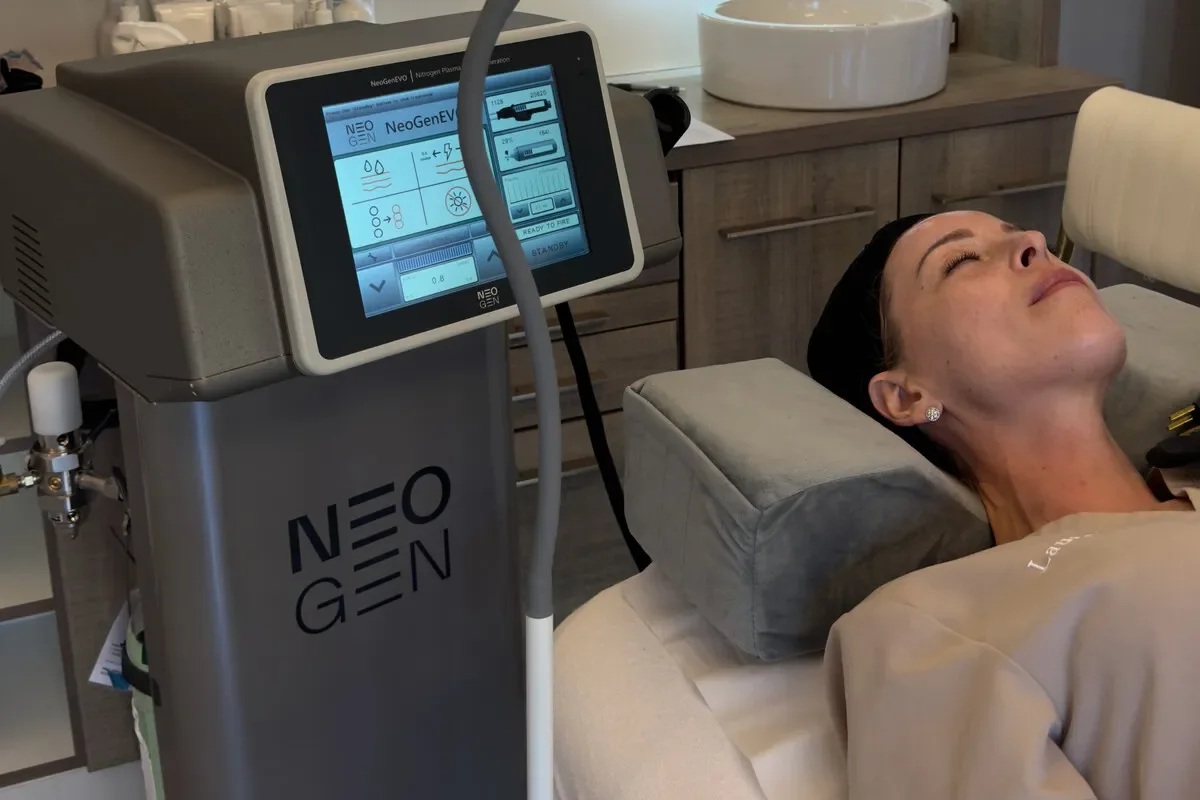 Client reclining beside a Neogen plasma device — iCRYO Westminster, CO wellness guide
