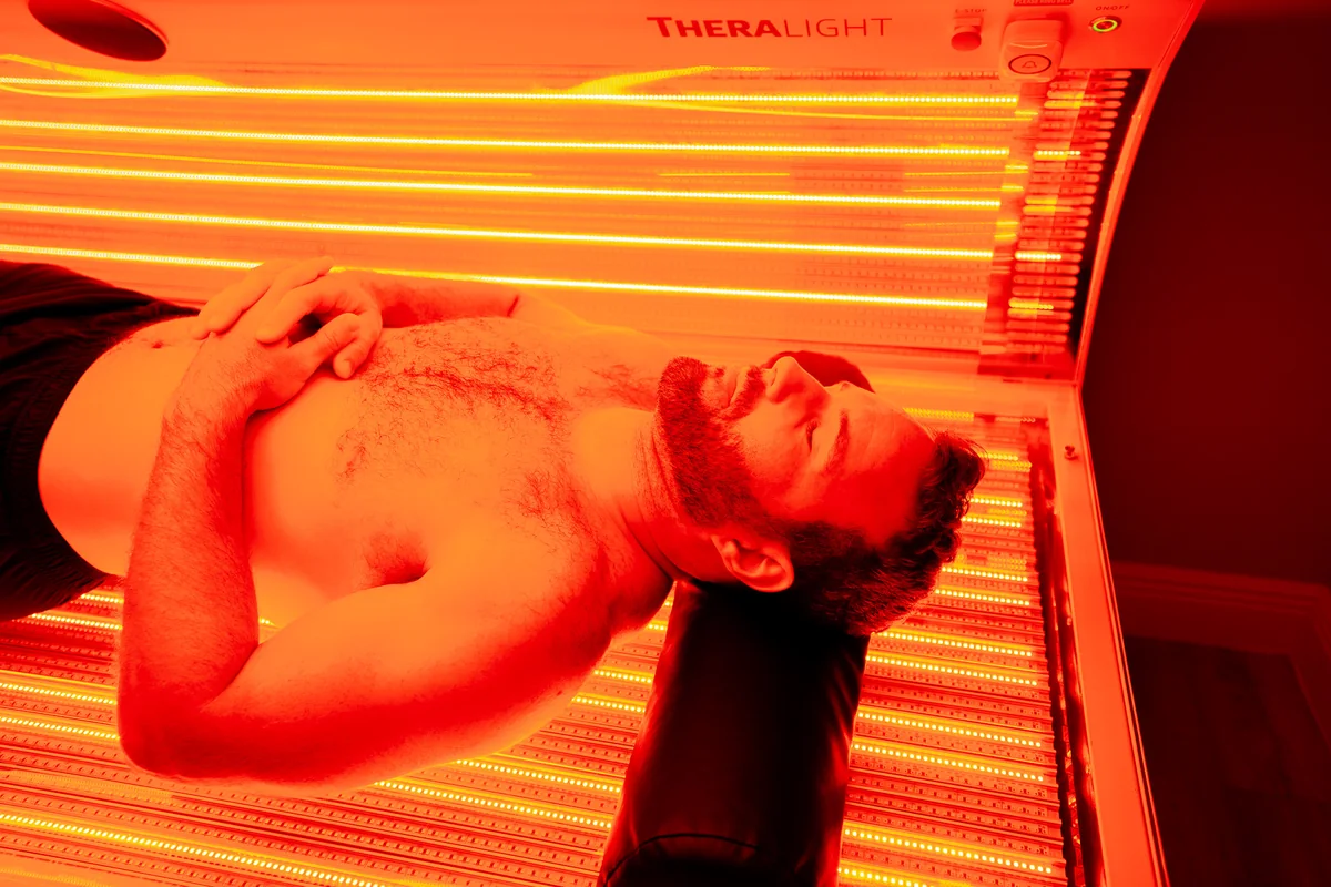 Client reclining under red light therapy lamps — iCRYO Westminster, CO wellness guide