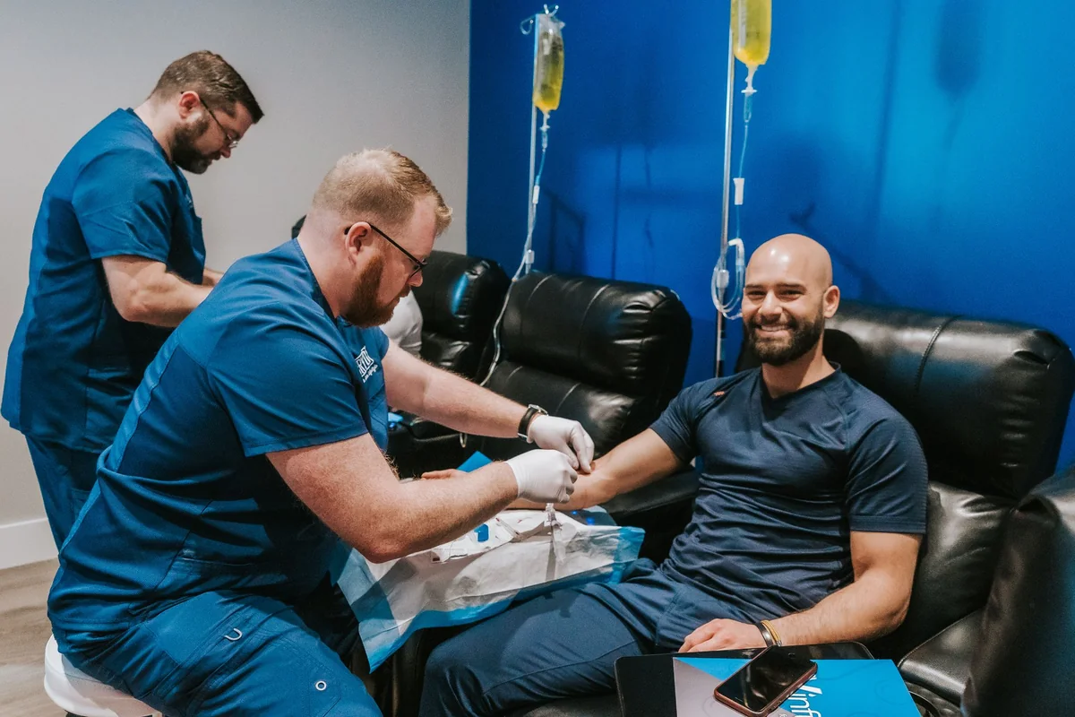 Clinician preparing an IV infusion for a seated client — iCRYO Westminster, CO wellness guide
