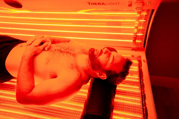 Client reclining under red light therapy lamps — iCRYO Westminster, CO wellness guide