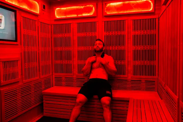 Client relaxing inside a red-lit infrared sauna — iCRYO Westminster, CO wellness guide