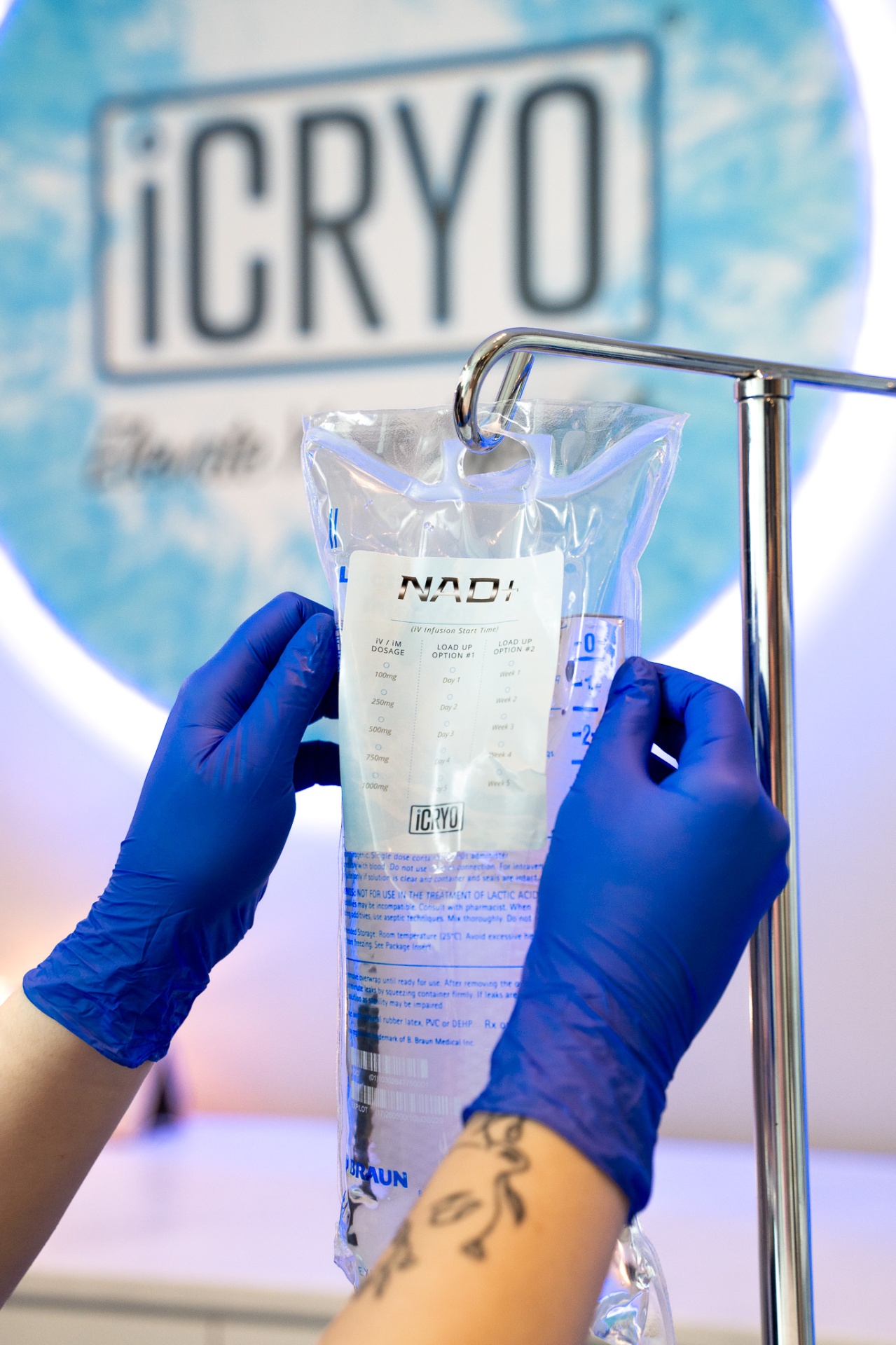 iCRYO Westminster RN holding a NAD+ IV bag in front of the iCRYO logo